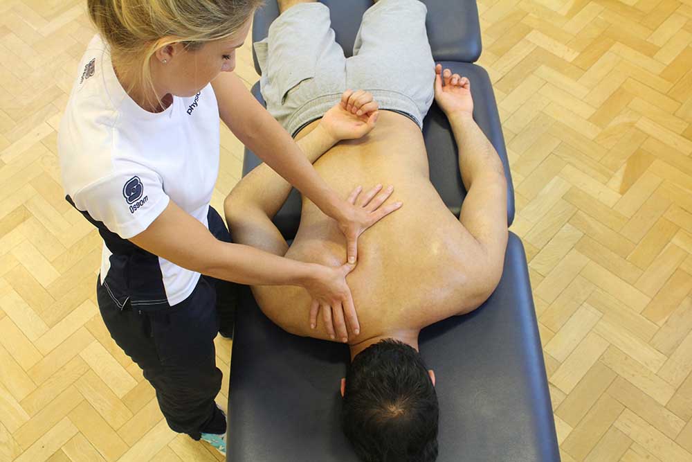 Trigger point massage of the rhomboid muscle by an experienced therapist