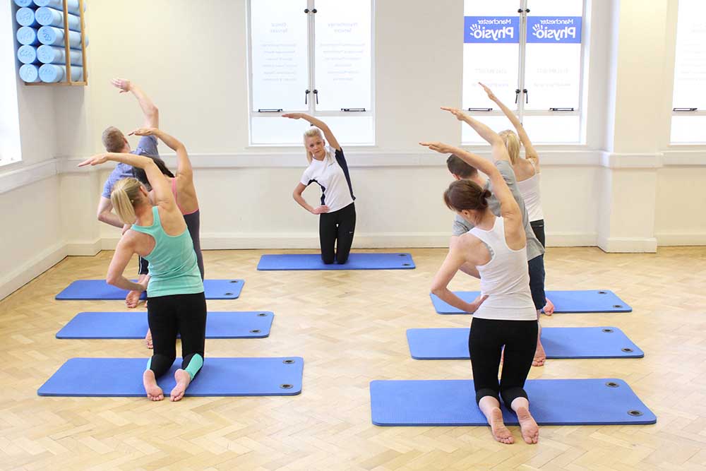 Group pilates session warm up on mats.