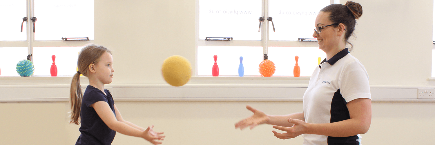 Young patient and physiotherapist play catch to aid in the recovery process.