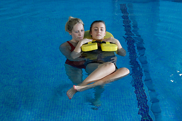 Female Recieves Hydrotherapy to aid recovery in pool.