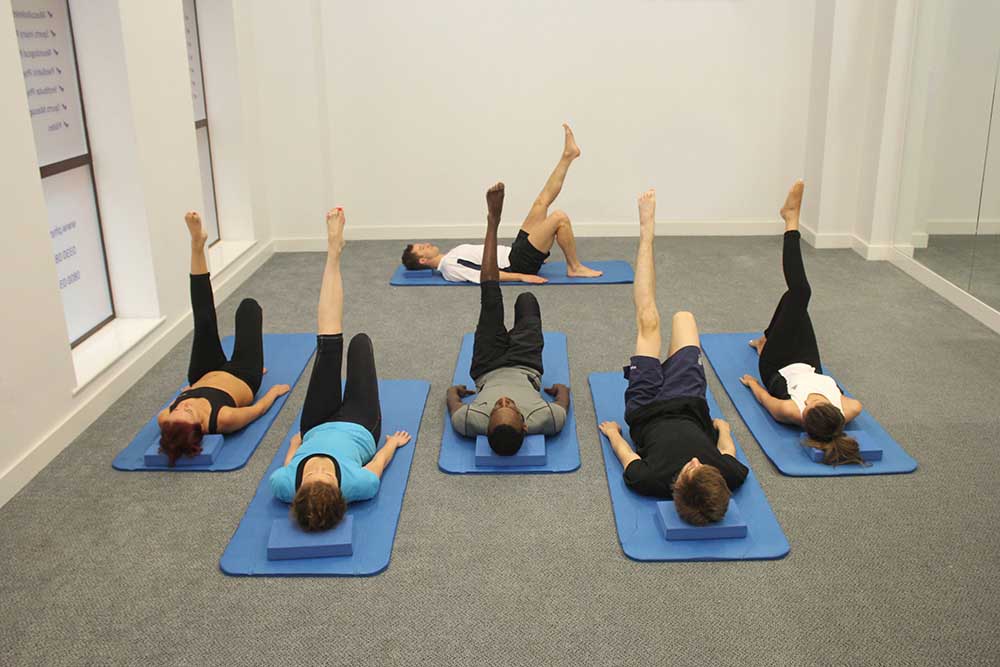 Beginners pilates class working on gentle core strengthening.