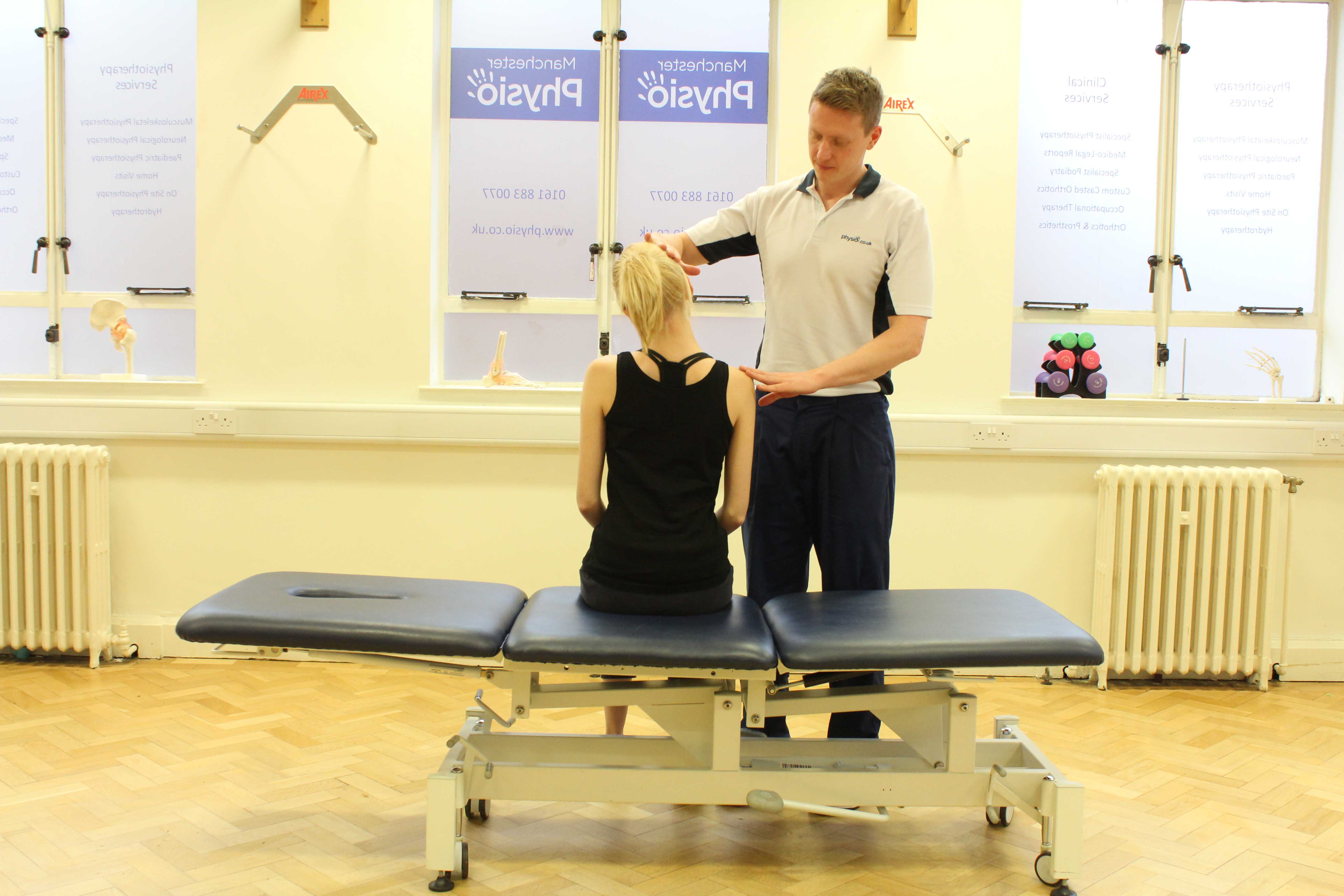 Experienced Physiotherapist conducting an assessment of the cervical spine, muscles and connective tissues in the neck Experienced Physiotherapist conducting an assessment of the cervical spine, muscles and connective tissues in the neck