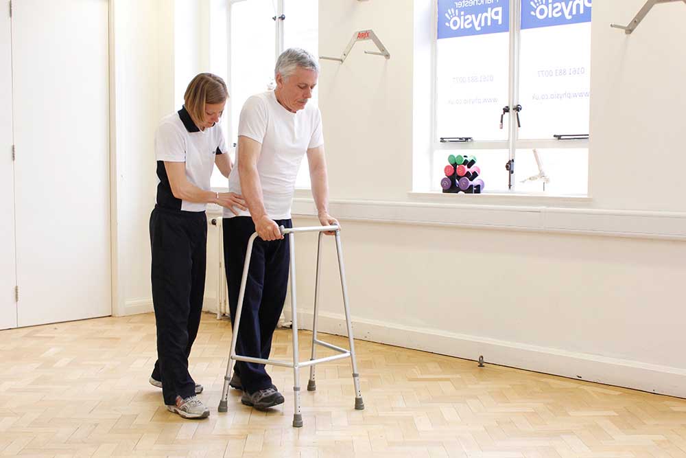 Physiotherapist supervising mobilisation using a walking frame
