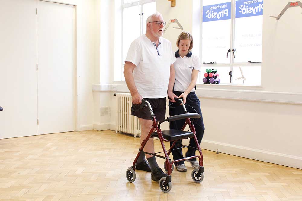 Physiotherapist supervising the use of a wheeled frame to minimise the risk of falls