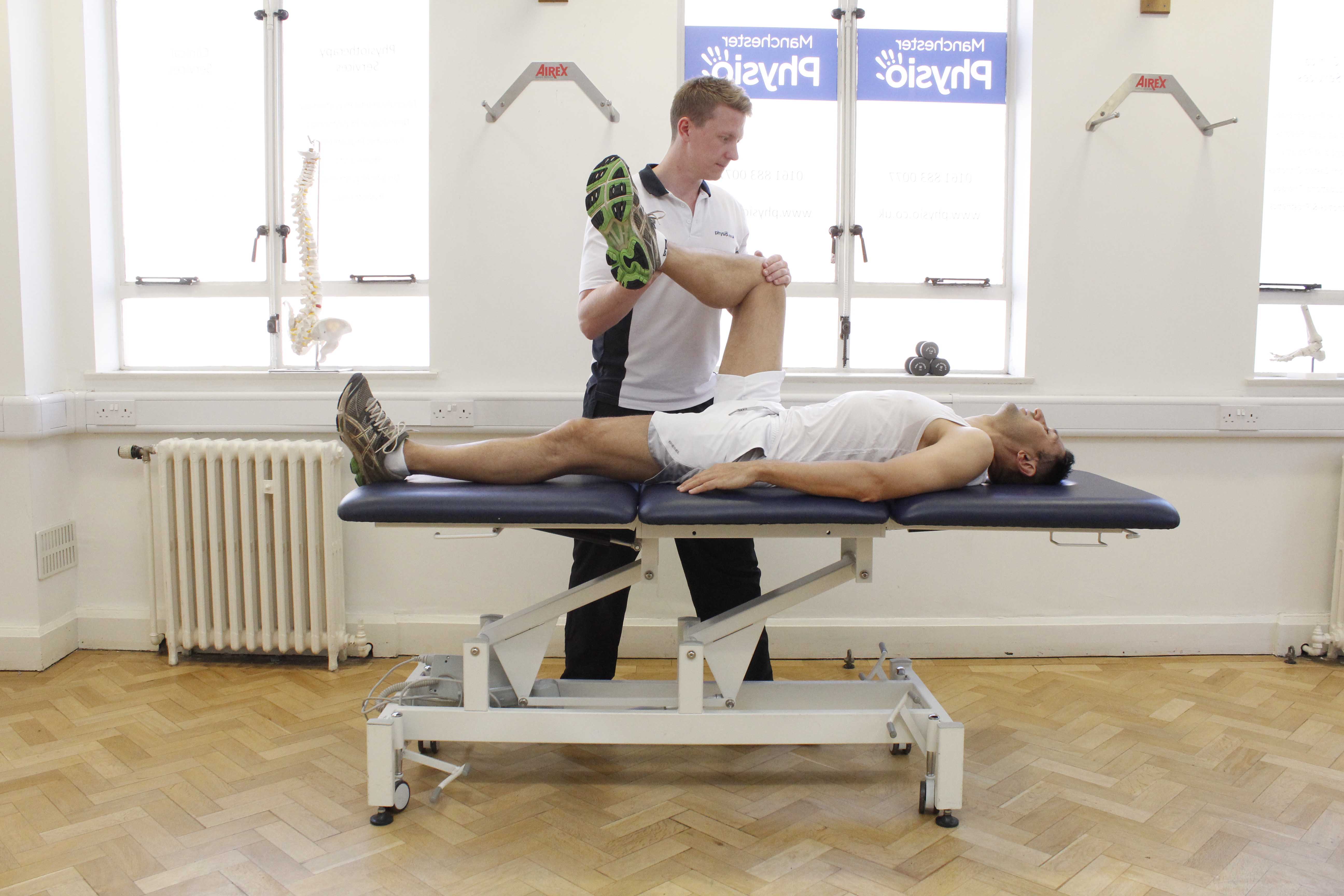 Experienced physiotherapist performing hip and knee stretches and mobilisations to reduce pain and muscle tone. Experienced physiotherapist performing hip and knee stretches and mobilisations to reduce pain and muscle tone.