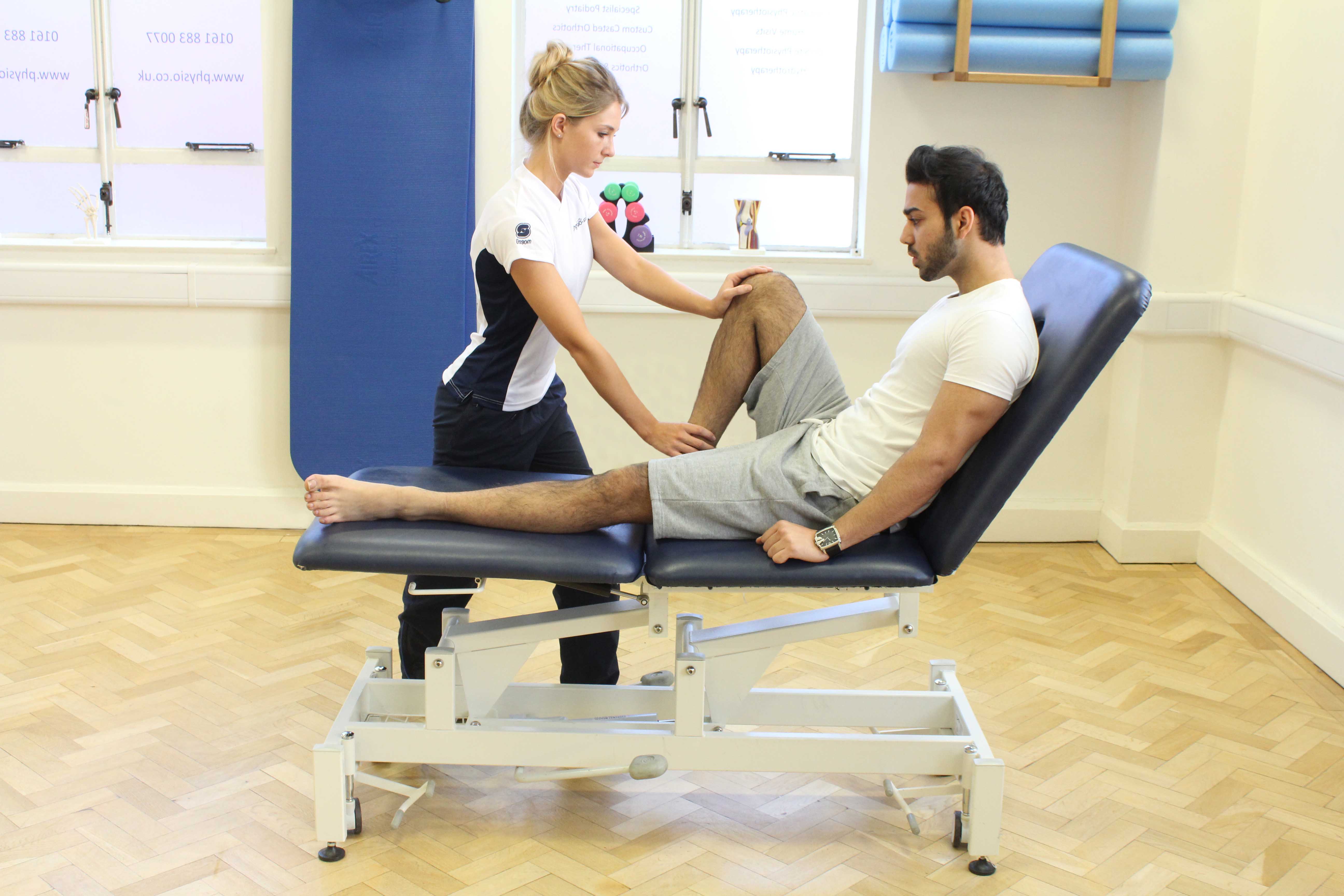 Therapist performing knee assessment