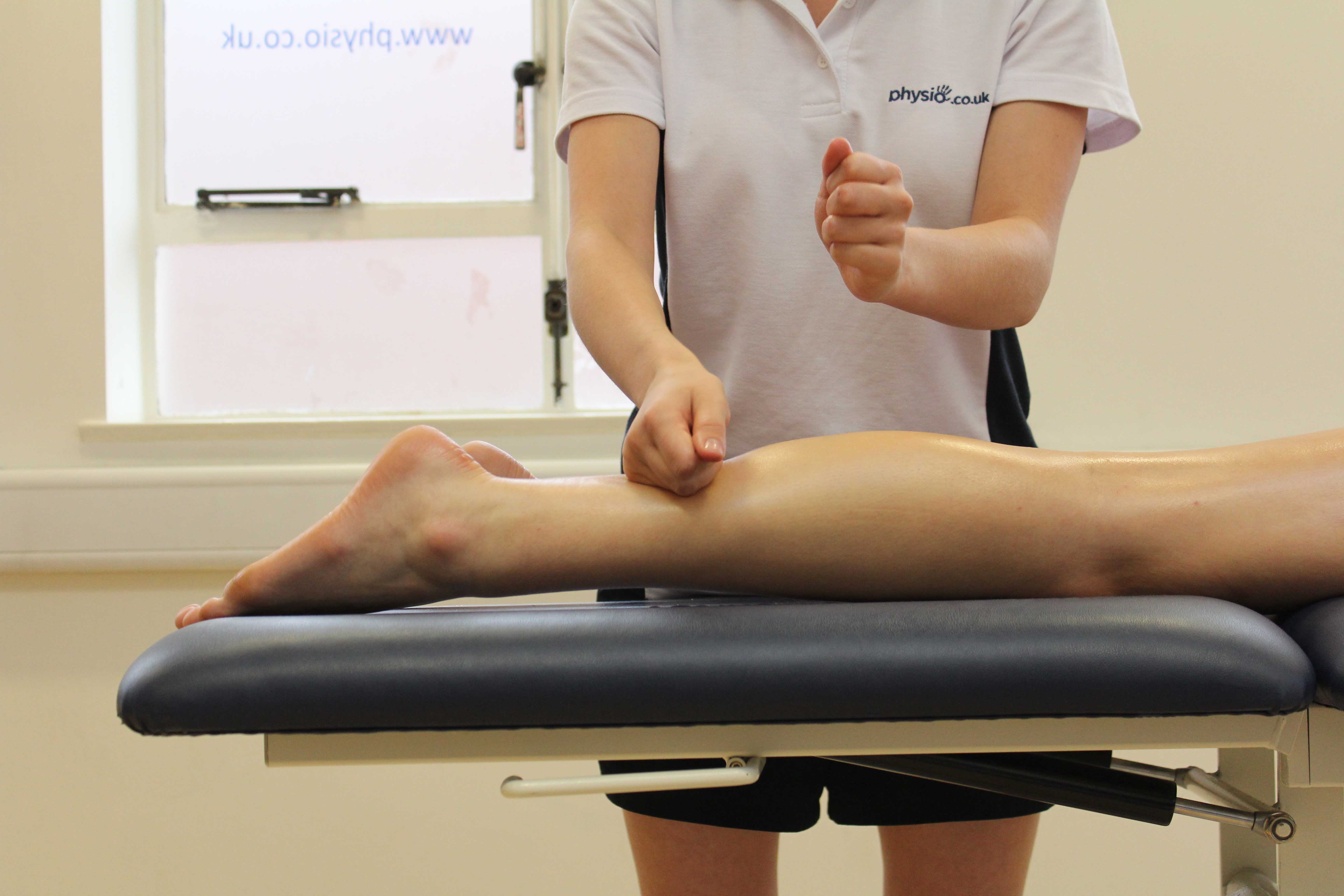 Beating percussion massage applied to the gastrocnemius muscle by experienced therapist Beating percussion massage applied to the gastrocnemius muscle by experienced therapist