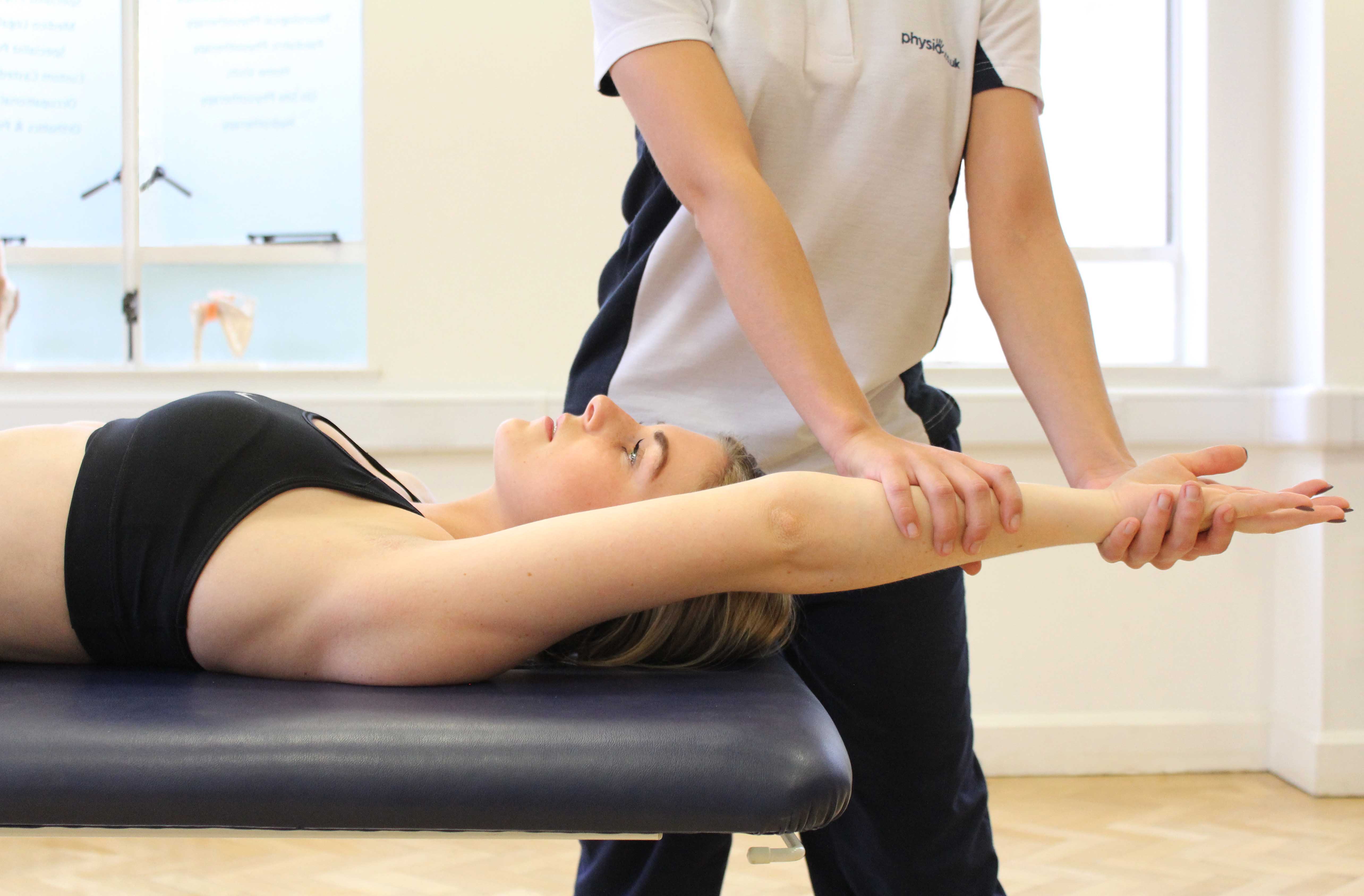 Passive stretch applied to the shoulder by experienced physiotherapist Passive stretch applied to the shoulder by experienced physiotherapist
