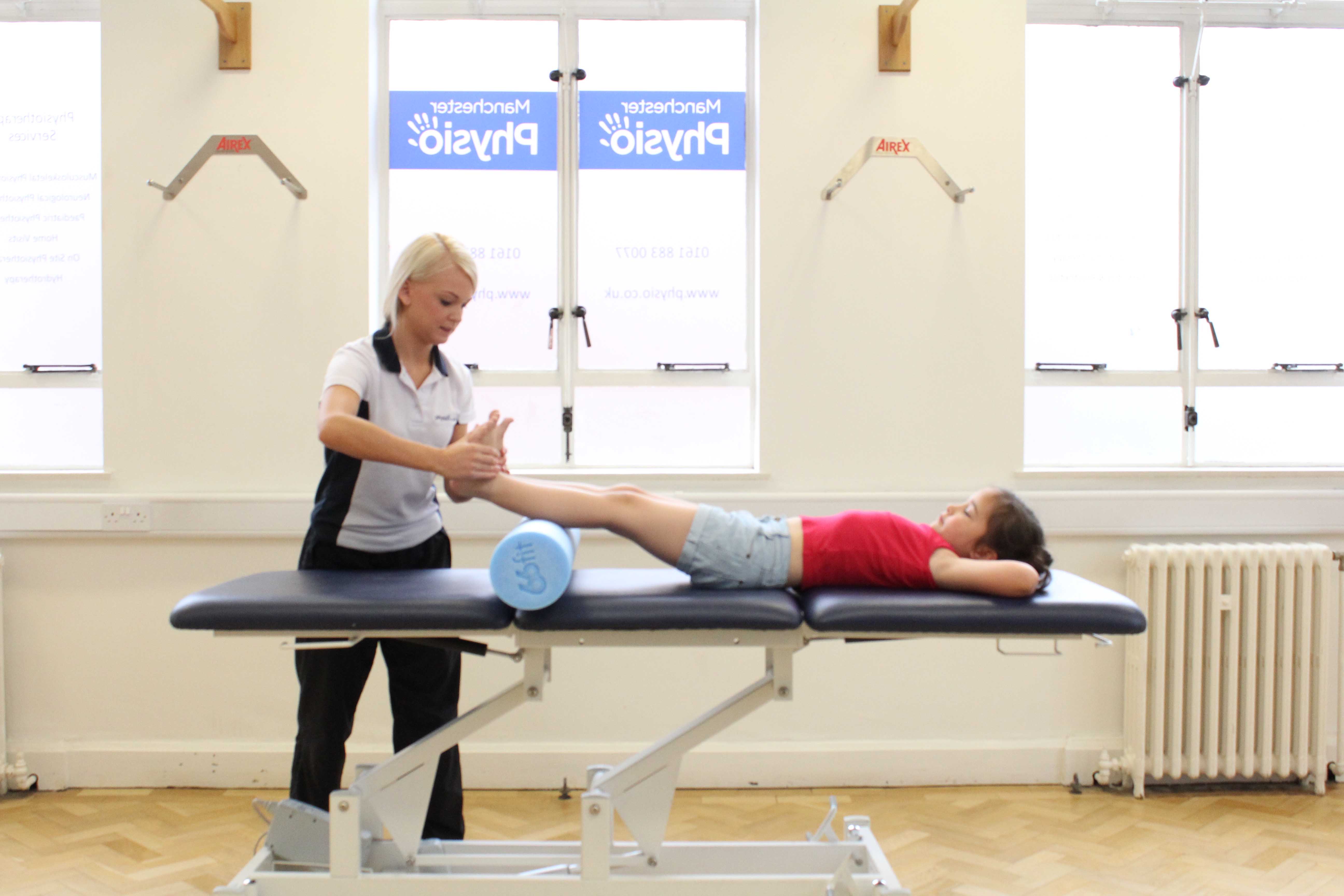 Therapist applies foot dorsiflex stretch to patient